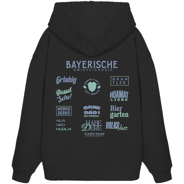 Schwarzer Bayerische Gmiatlichkeit Oversize Hoodie mit großem grünem Backprint und bayerischen Symbolen. Unisex Premium-Hoodie aus Bio-Baumwolle im modernen Streetwear-Look für Biergarten, Volksfest und Freizeit. Designed und bedruckt in Bayern von Grantler Gwand.