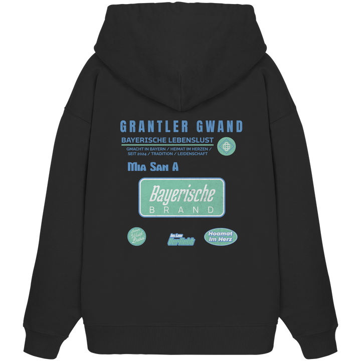 Schwarzer Oversize Hoodie mit großem Grantler Gwand Backprint, blau-grünem „Bayerische Brand“-Schriftzug und moderner bayerischer Streetwear-Grafik.