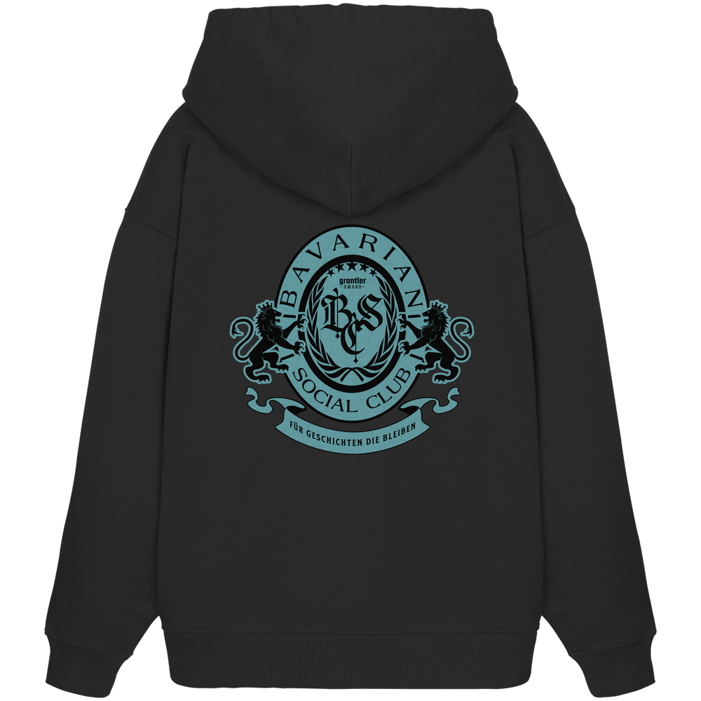 schwarzer Oversize Hoodie mit großem mintfarben-schwarzem Bavarian Social Club Wappen auf dem Rücken, verziert mit Lorbeerkranz, Löwen und dem Schriftzug „Für Geschichten die bleiben“.