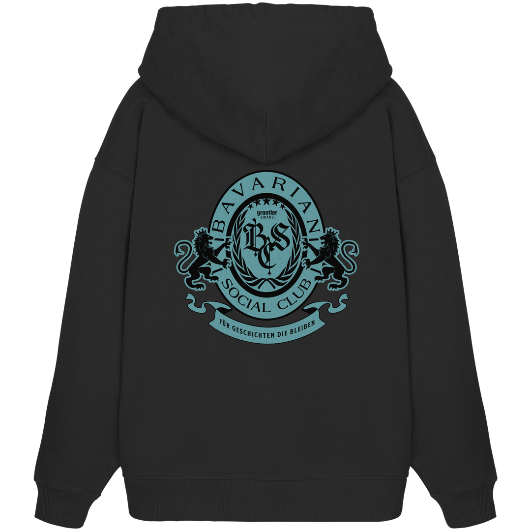 schwarzer Oversize Hoodie mit großem mintfarben-schwarzem Bavarian Social Club Wappen auf dem Rücken, verziert mit Lorbeerkranz, Löwen und dem Schriftzug „Für Geschichten die bleiben“.