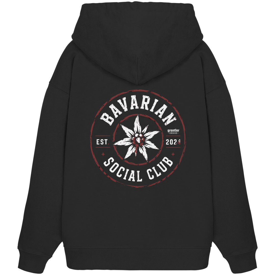 Schwarzer Oversize Hoodie mit großem runden „Bavarian Social Club“-Backprint, weißem Edelweiß in der Mitte sowie Vintage-Details in Weiß und Dunkelrot.