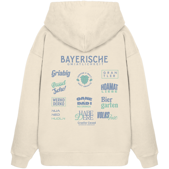 Beiger Bayerische Gmiatlichkeit Oversize Hoodie mit großem grünem Backprint und bayerischen Symbolen. Unisex Premium-Hoodie aus Bio-Baumwolle im modernen Streetwear-Look für Biergarten, Volksfest und Freizeit. Designed und bedruckt in Bayern von Grantler Gwand.