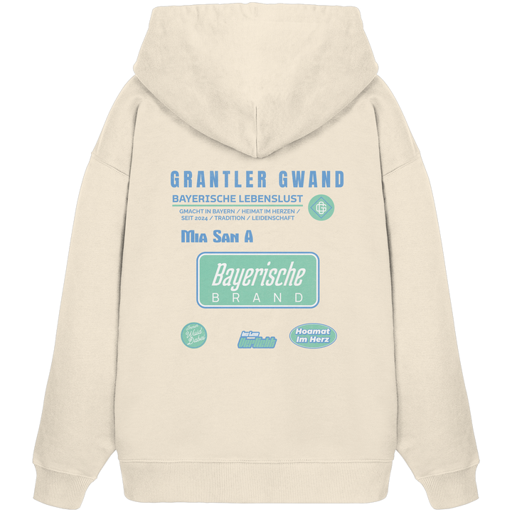 Naturfarbener Oversize Hoodie mit großem Grantler Gwand Backprint, blau-grünem „Bayerische Brand“-Schriftzug und moderner bayerischer Streetwear-Grafik.