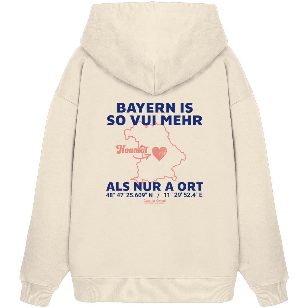 Cremefarbener Oversize Hoodie von Grantler Gwand mit blauem Backprint „Bayern is so vui mehr als nur a Ort“, Herzsymbol und Bayern-Silhouette – bayerischer Streetwear Hoodie.
