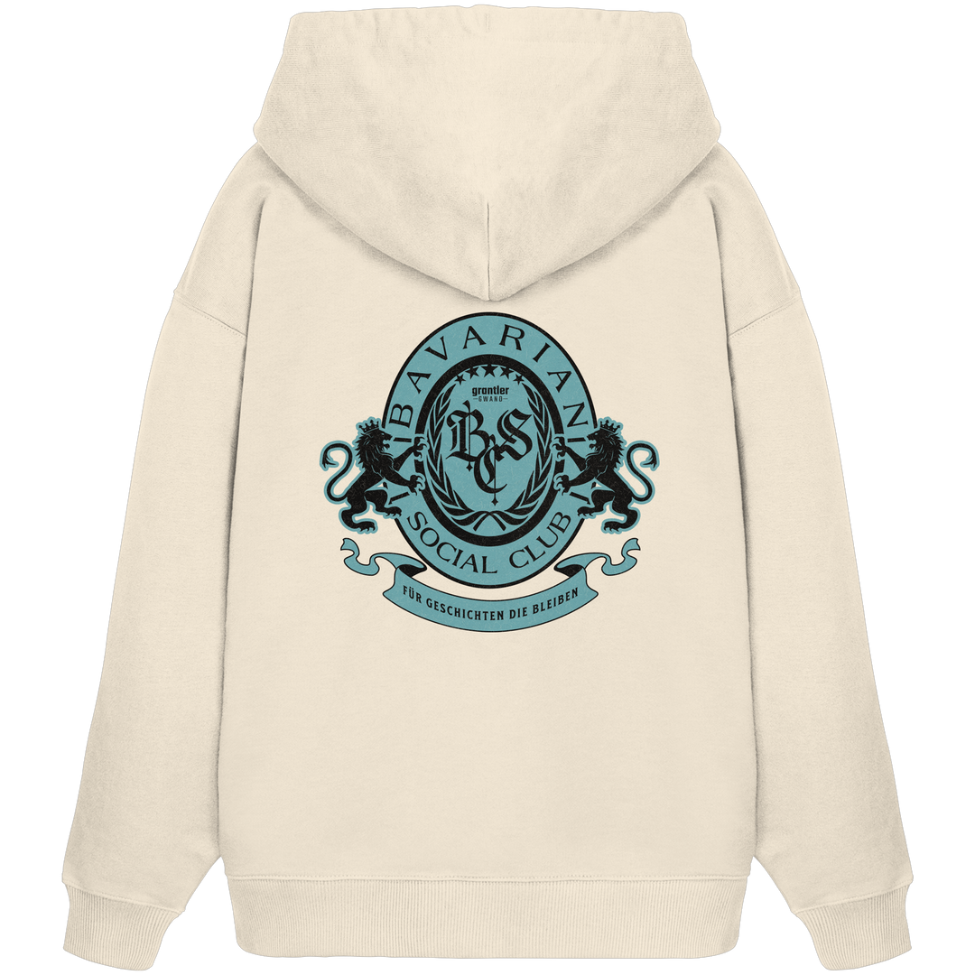 naturfarbener Oversize Hoodie mit großem mintfarben-schwarzem Bavarian Social Club Wappen auf dem Rücken, verziert mit Lorbeerkranz, Löwen und dem Schriftzug „Für Geschichten die bleiben“.