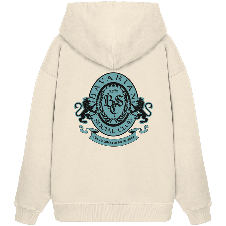 naturfarbener Oversize Hoodie mit großem mintfarben-schwarzem Bavarian Social Club Wappen auf dem Rücken, verziert mit Lorbeerkranz, Löwen und dem Schriftzug „Für Geschichten die bleiben“.