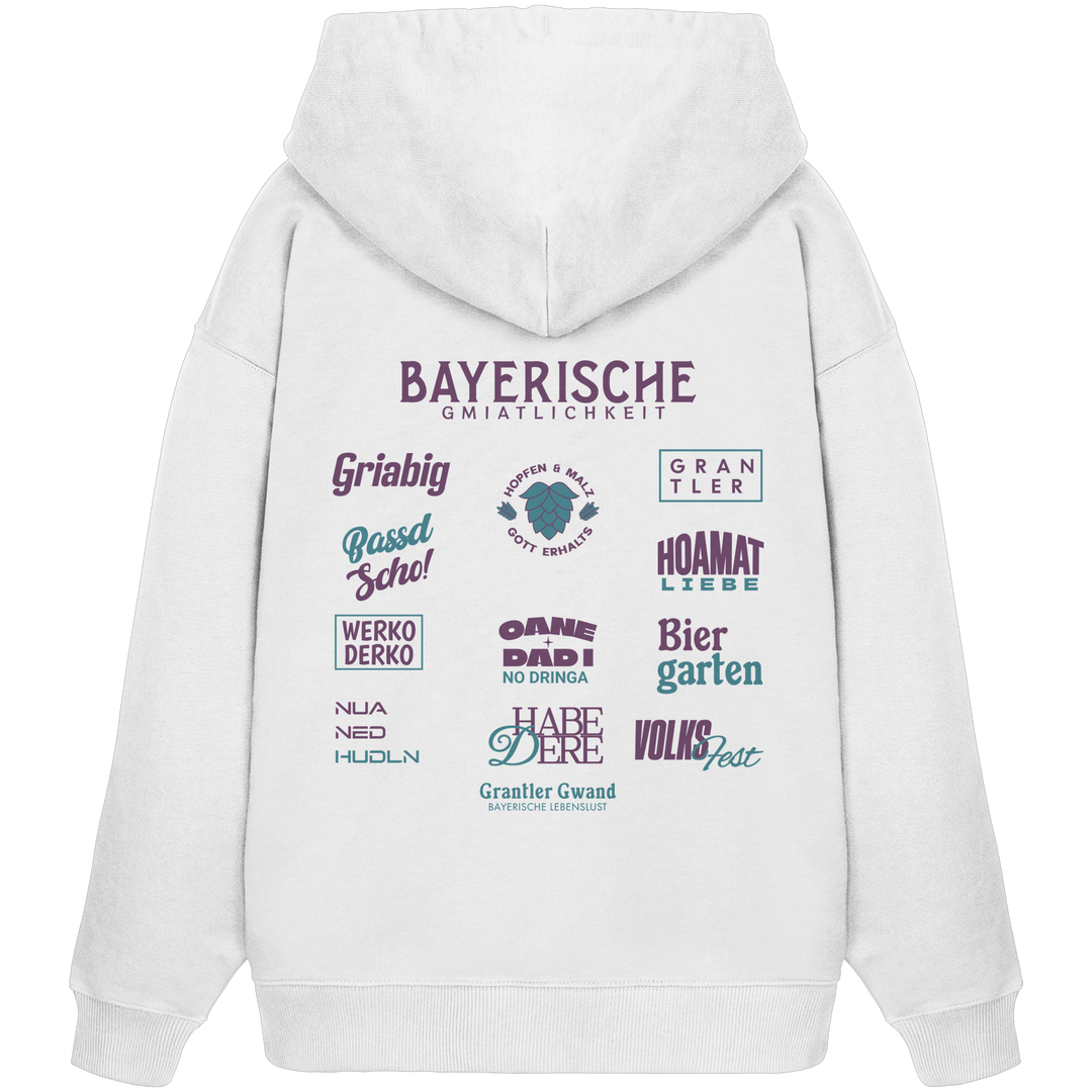 Weißer Oversize Hoodie mit großem lila Backprint „Bayerische Gmiatlichkeit“ und bayerischen Begriffen wie Hoamatliebe, Biergarten, Volksfest, Grantler, Hopfen & Malz und Griabig. Unisex Premium-Hoodie aus Bio-Baumwolle im modernen Streetwear-Style. Designed und bedruckt in Bayern von Grantler Gwand.