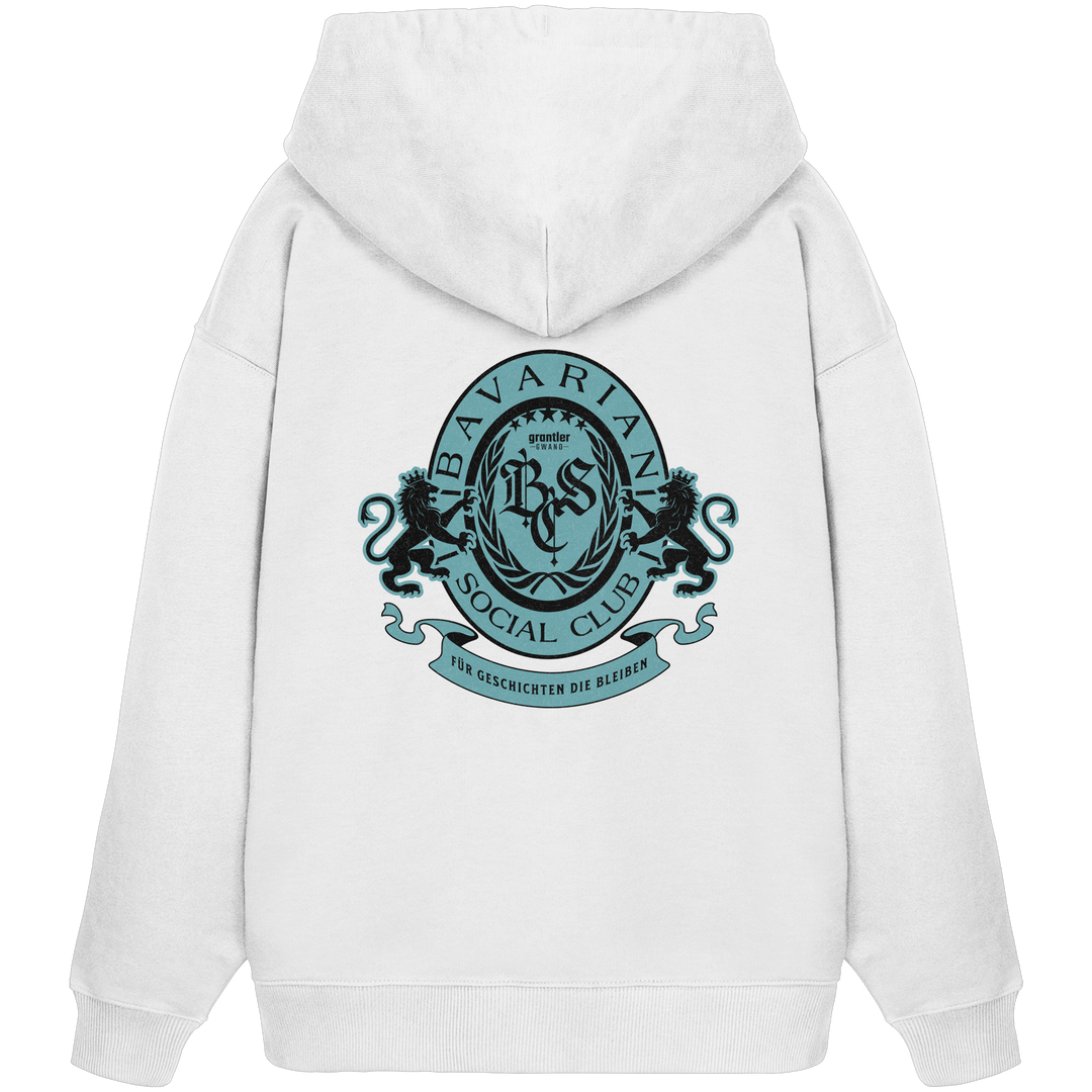 Weißer Oversize Hoodie mit großem mintfarben-schwarzem Bavarian Social Club Wappen auf dem Rücken, verziert mit Lorbeerkranz, Löwen und dem Schriftzug „Für Geschichten die bleiben“.