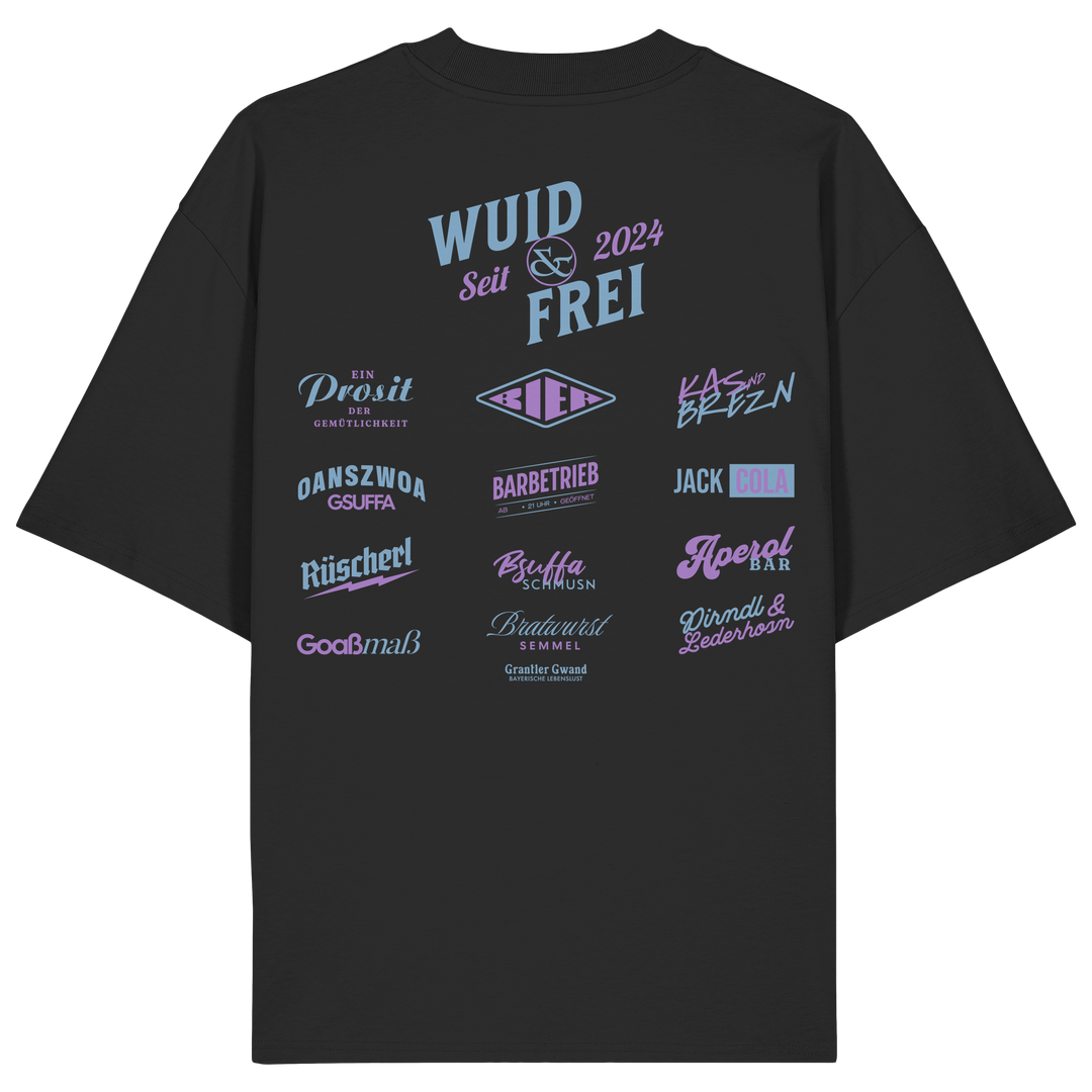 Schwarzes oversize Shirt mit großem Backprint „Wuid &amp; Frei seit 2024“ sowie verschiedenen bayerischen Typografie-Designs und Dialektbegriffen.