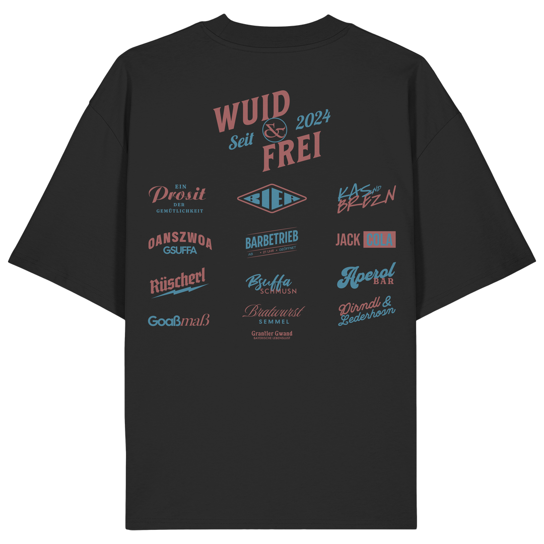 Schwarzes oversize Shirt mit großem Backprint „Wuid &amp; Frei seit 2024“ sowie verschiedenen bayerischen Typografie-Designs und Dialektbegriffen.