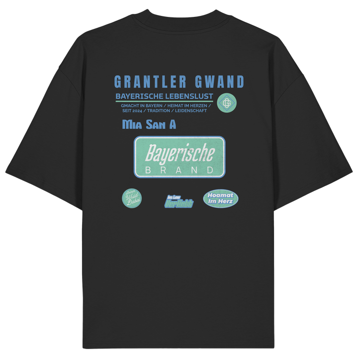 schwarzes Oversize T-Shirt mit großem Grantler Gwand Backprint in Blau und Mintgrün sowie dem Schriftzug „Bayerische Brand“ im modernen Streetwear-Design.