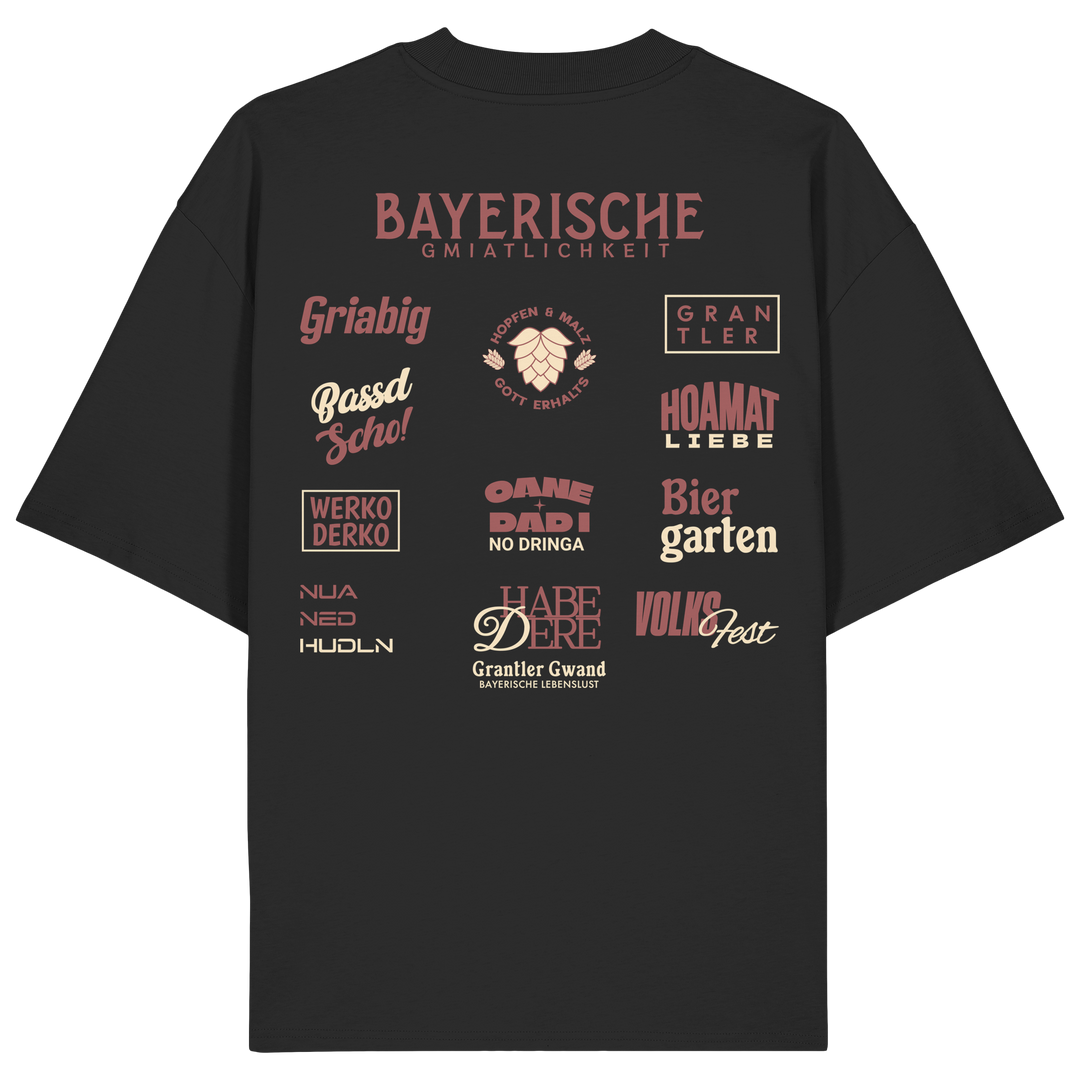 Schwarzes Oversize-Shirt mit großem rotem Backprint „Bayerische Gmiatlichkeit“ und typischen bayerischen Begriffen wie Hoamatliebe, Biergarten, Volksfest, Grantler, Hopfen & Malz und Griabig. Unisex Premium-Shirt aus Bio-Baumwolle im modernen Streetwear-Style. Designed und bedruckt in Bayern von Grantler Gwand.