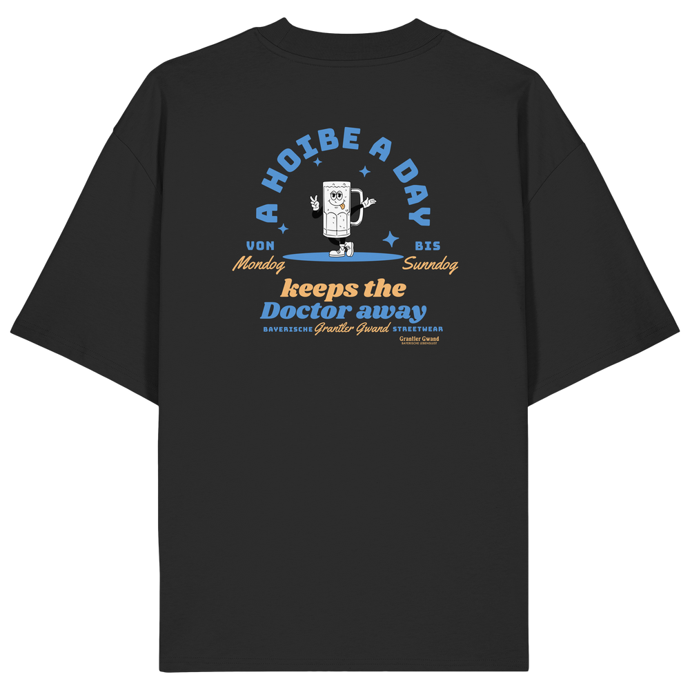 Schwarzes Oversize T-Shirt von Grantler Gwand mit Backprint „A Hoibe a Day keeps the Doctor away“, Bierkrug-Maskottchen im Retro-Design und hellblauen Details – bayerisches Streetwear Shirt aus Bio-Baumwolle.