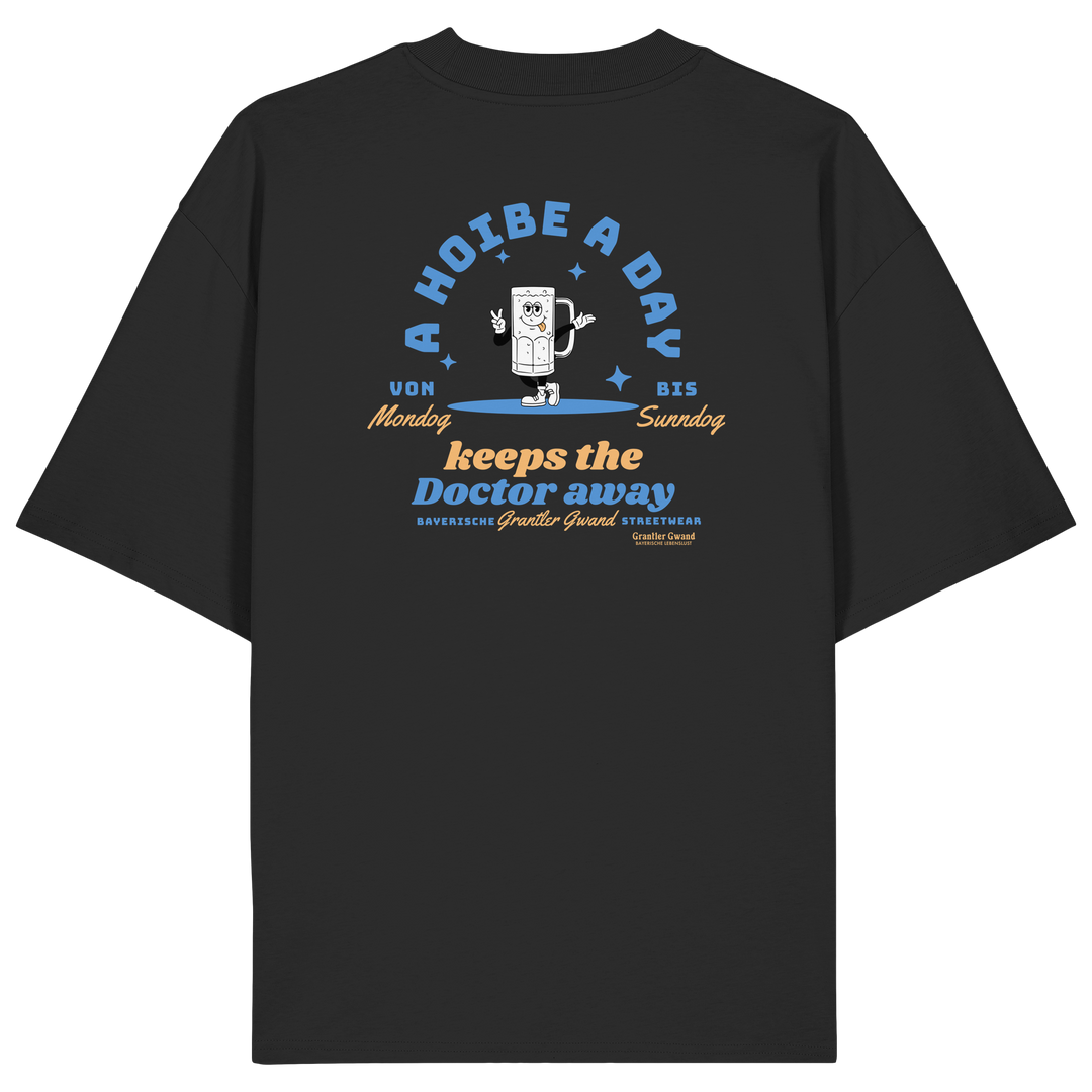 Schwarzes Oversize T-Shirt von Grantler Gwand mit Backprint „A Hoibe a Day keeps the Doctor away“, Bierkrug-Maskottchen im Retro-Design und hellblauen Details – bayerisches Streetwear Shirt aus Bio-Baumwolle.