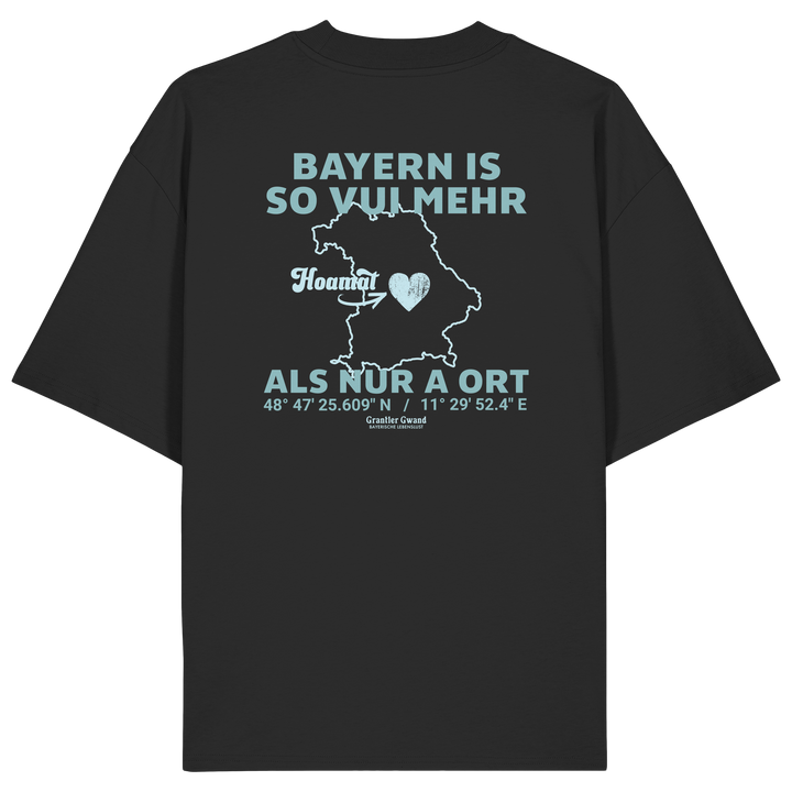 Schwarzes Oversize T-Shirt von Grantler Gwand mit grünem Backprint „Bayern is so vui mehr als nur a Ort“ und Bayern-Silhouette – bayerisches Streetwear Shirt aus Bio-Baumwolle.