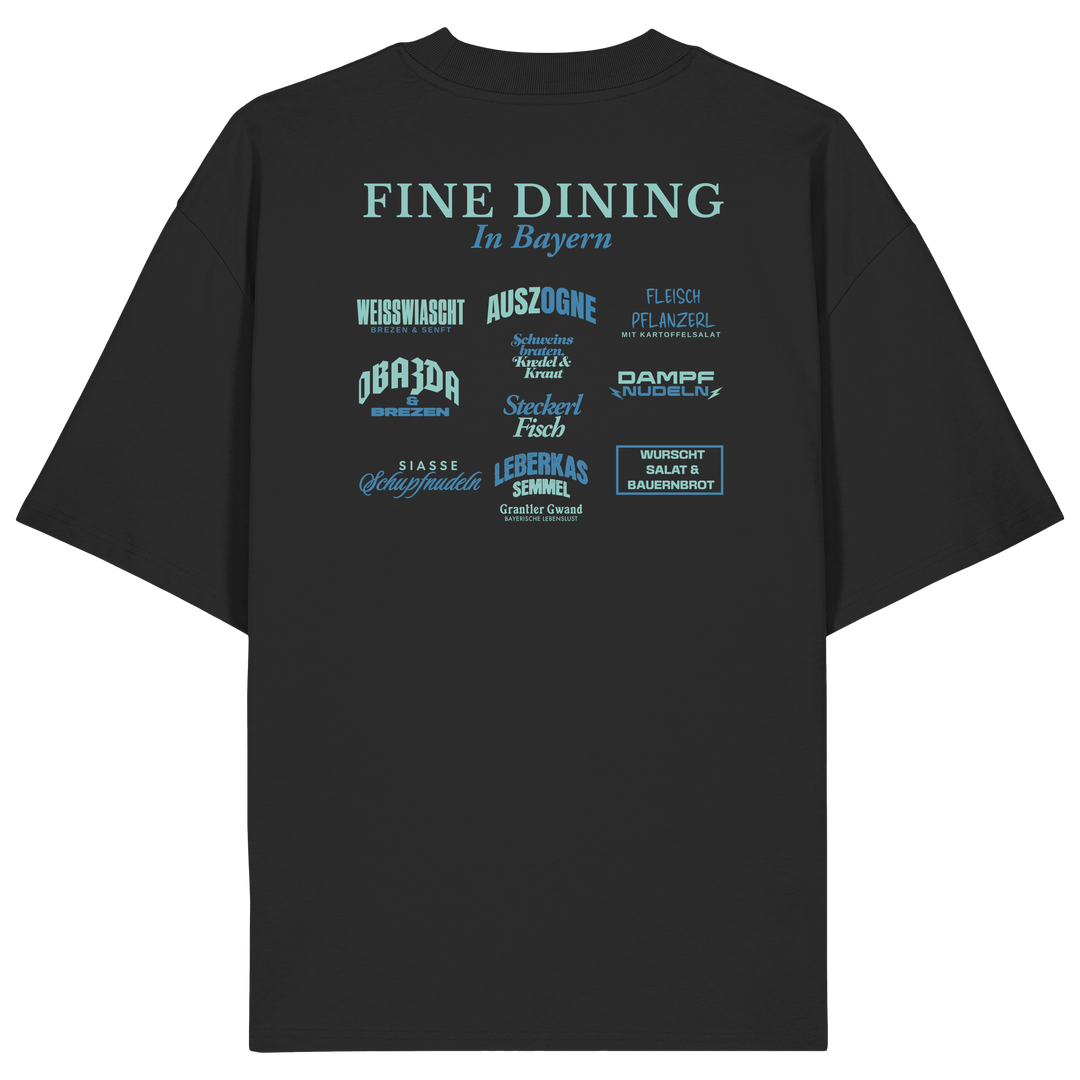 Schwarzes Oversize-T-Shirt in bio Qualität mit grünem „Fine Dining in Bayern“-Backprint – bayerische Streetwear mit humorvollem Motiv rund um bayerische Küche von Grantler Gwand.