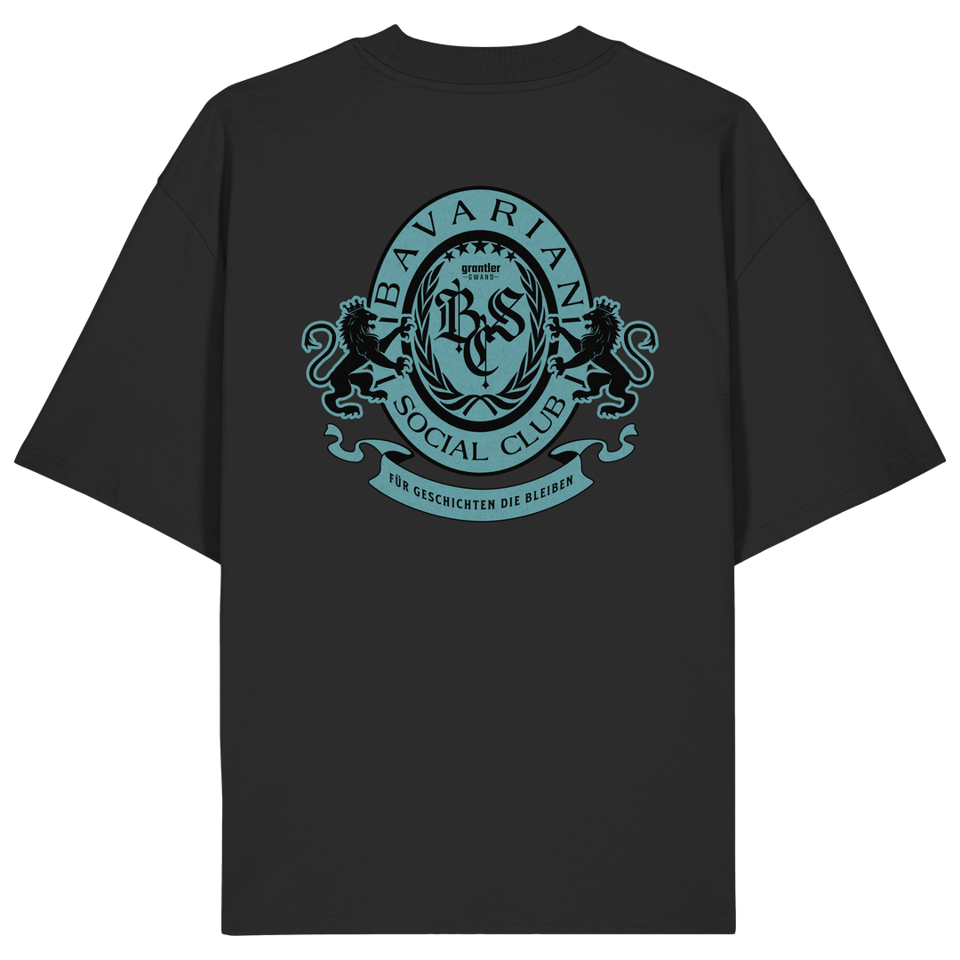 schwarzes Oversize T-Shirt mit großem mintfarben-schwarzem Bavarian Social Club Wappen auf dem Rücken, verziert mit zwei Löwen, Lorbeerkranz und dem Schriftzug „Für Geschichten die bleiben“.