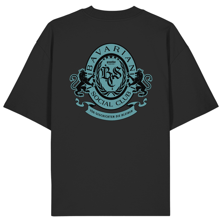 schwarzes Oversize T-Shirt mit großem mintfarben-schwarzem Bavarian Social Club Wappen auf dem Rücken, verziert mit zwei Löwen, Lorbeerkranz und dem Schriftzug „Für Geschichten die bleiben“.