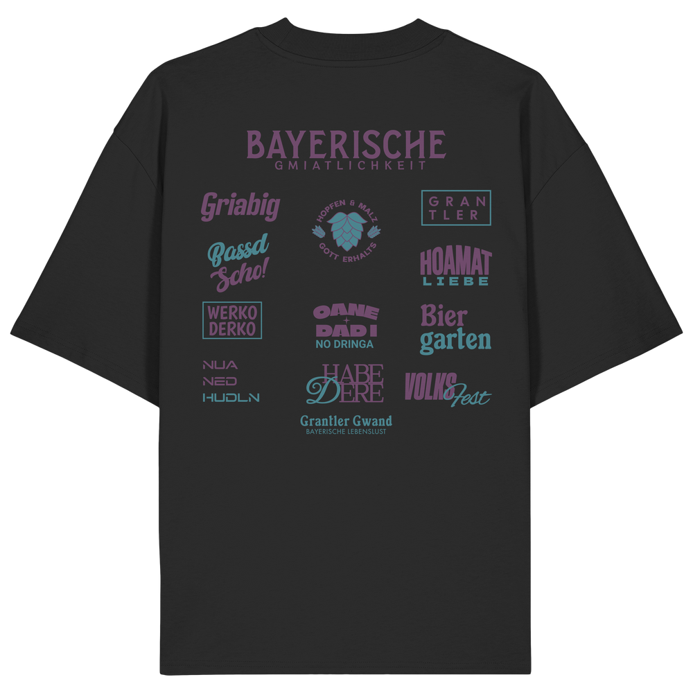 Schwarzes Oversize-Shirt mit großem lila Backprint „Bayerische Gmiatlichkeit“ und typischen bayerischen Begriffen wie Hoamatliebe, Biergarten, Volksfest, Grantler, Hopfen & Malz und Griabig. Unisex Premium-Shirt aus Bio-Baumwolle im modernen Streetwear-Style. Designed und bedruckt in Bayern von Grantler Gwand.