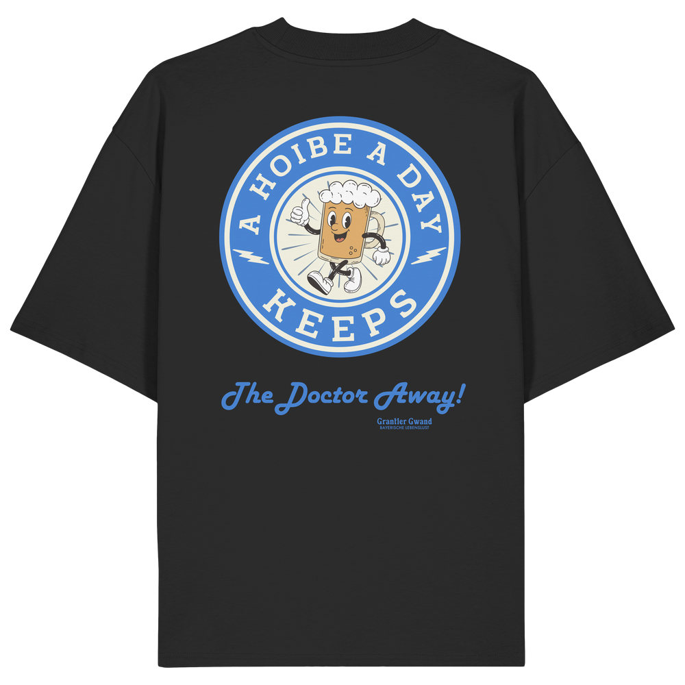 Oversize Unisex-Shirt in Schwarz mit großem Backprint „A Hoibe A Day – Keeps the Doctor Away“ im Retro-Bierdeckel-Design mit blauen Akzenten. Modernes bayerisches Streetwear-Shirt für Biergarten, Volksfest und gesellige Momente. Designed und bedruckt in Bayern von Grantler Gwand.