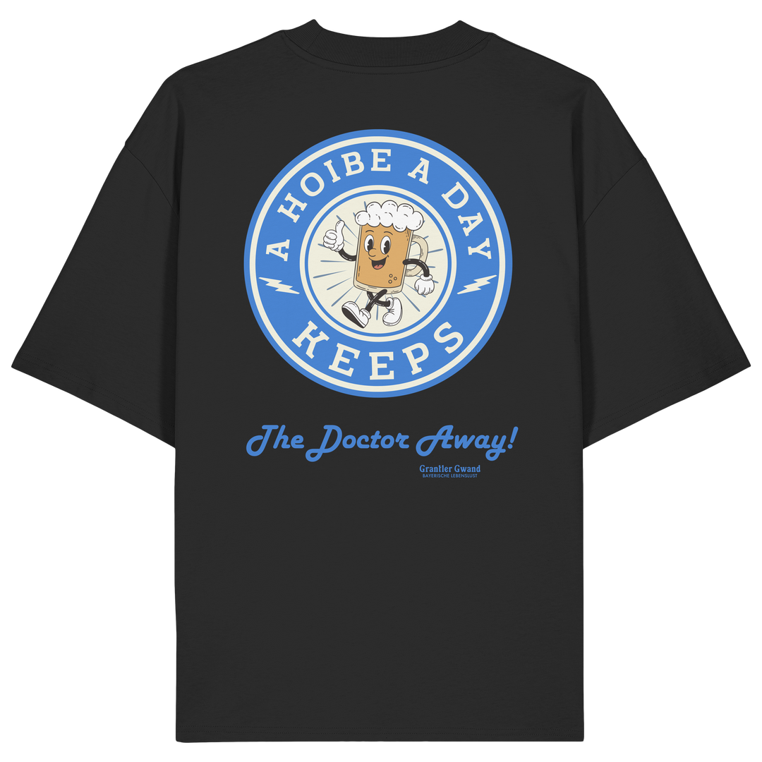 Oversize Unisex-Shirt in Schwarz mit großem Backprint „A Hoibe A Day – Keeps the Doctor Away“ im Retro-Bierdeckel-Design mit blauen Akzenten. Modernes bayerisches Streetwear-Shirt für Biergarten, Volksfest und gesellige Momente. Designed und bedruckt in Bayern von Grantler Gwand.