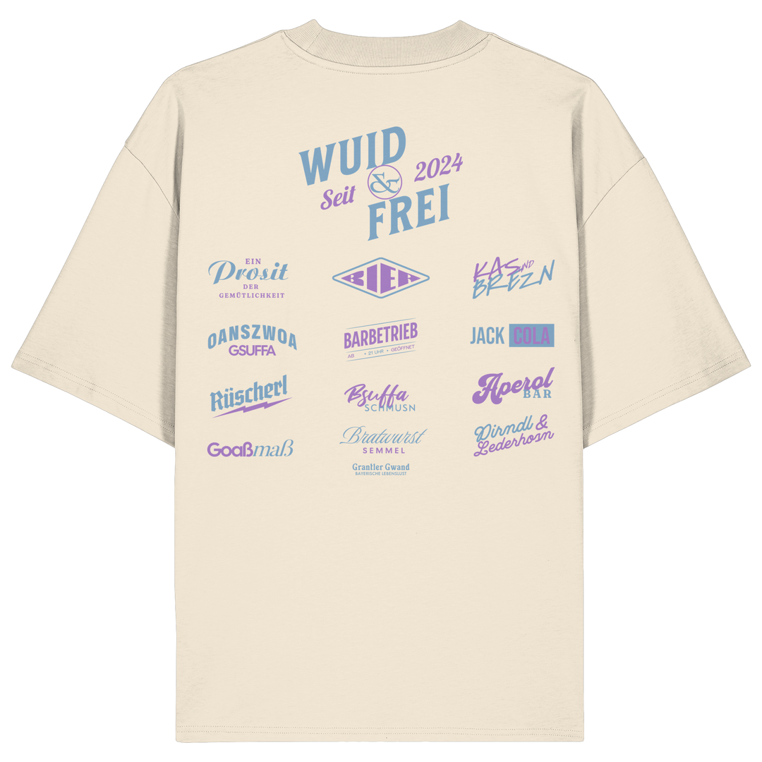 Naturfarbenes oversize Shirt mit großem Backprint „Wuid &amp; Frei seit 2024“ sowie verschiedenen bayerischen Typografie-Designs und Dialektbegriffen.