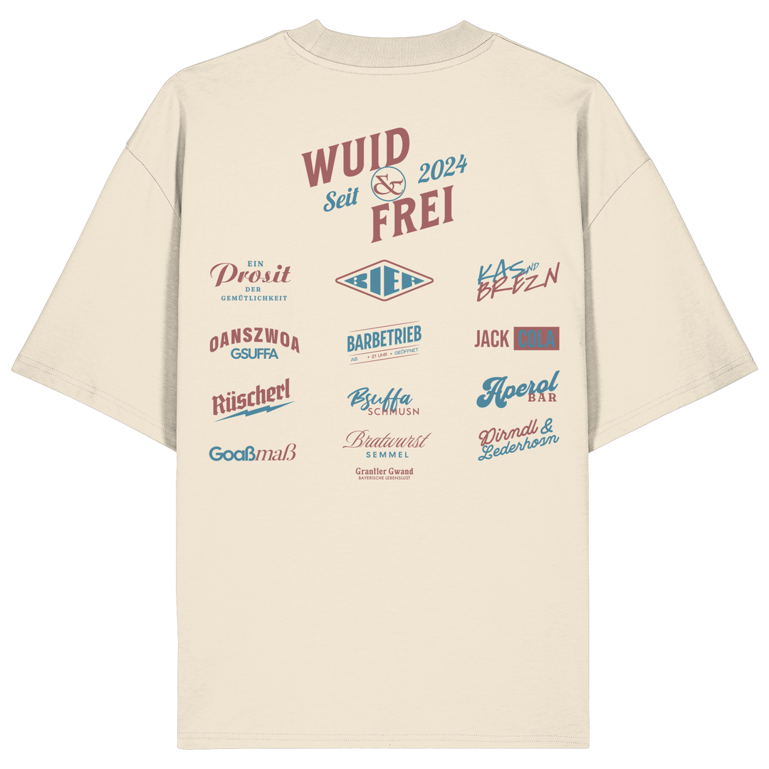 Naturfarbenes oversize Shirt mit großem Backprint „Wuid &amp; Frei seit 2024“ sowie verschiedenen bayerischen Typografie-Designs und Dialektbegriffen.