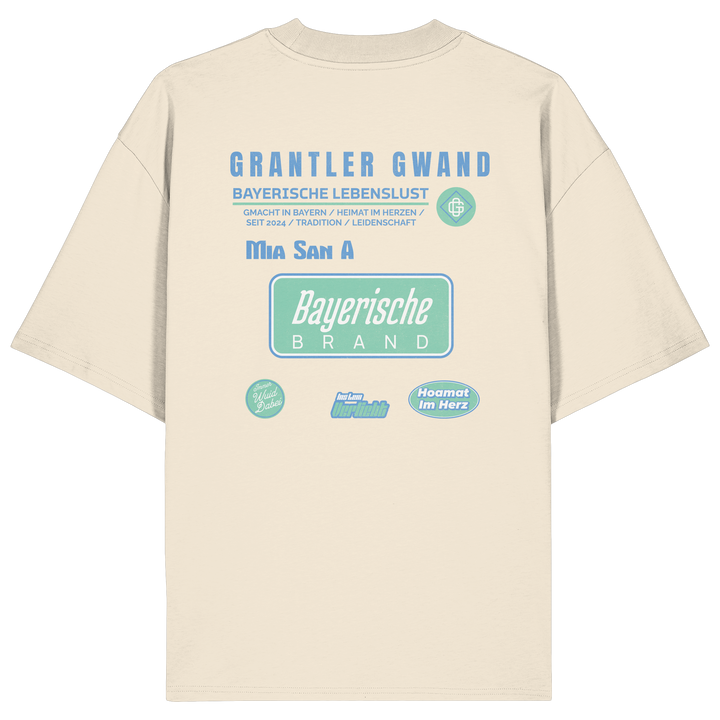Naturfarbenes Oversize T-Shirt mit großem Grantler Gwand Backprint in Blau und Mintgrün sowie dem Schriftzug „Bayerische Brand“ im modernen Streetwear-Design.