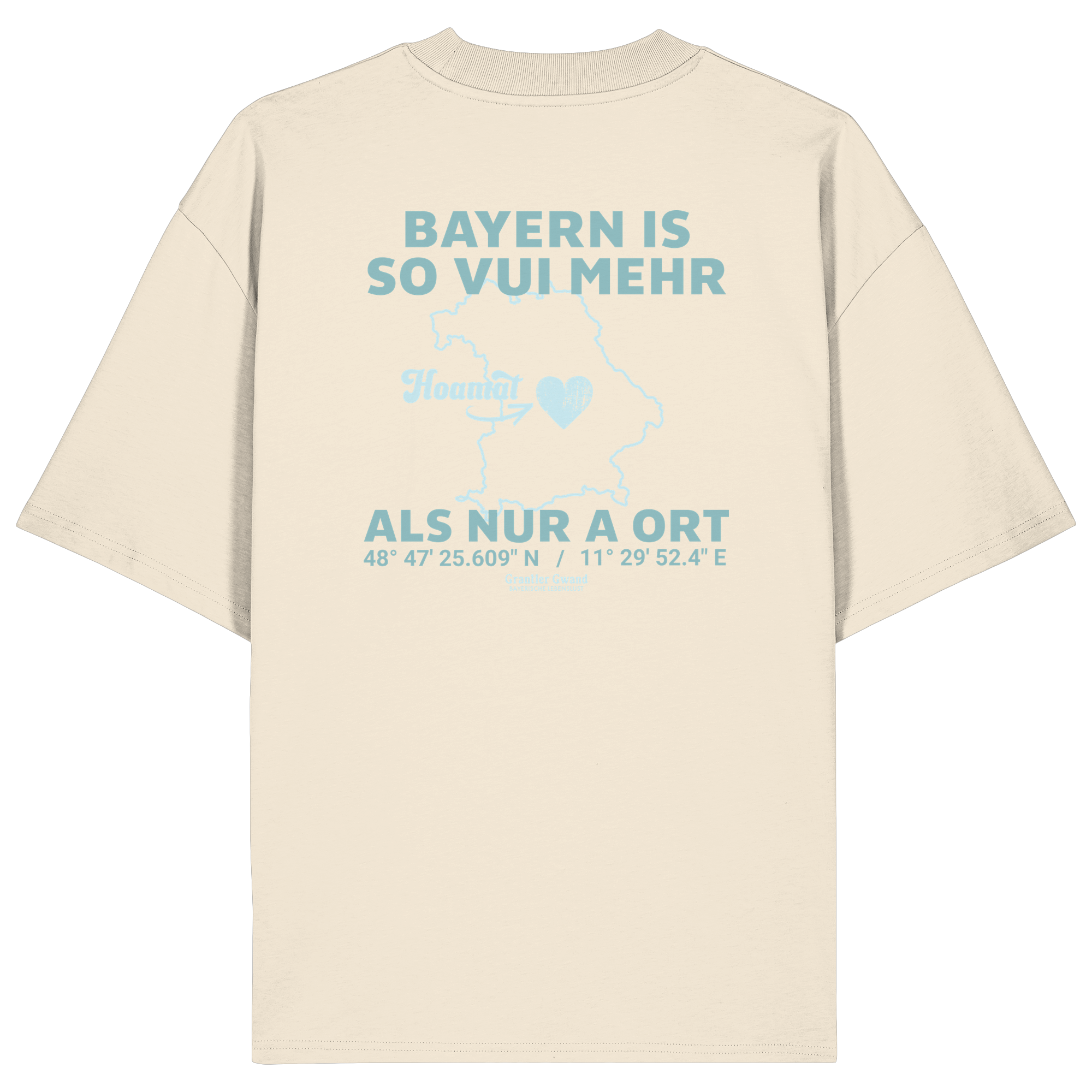 Cremefarbenes Oversize T-Shirt von Grantler Gwand mit grünem Backprint „Bayern is so vui mehr als nur a Ort“ und Bayern-Silhouette – bayerisches Streetwear Shirt aus Bio-Baumwolle.