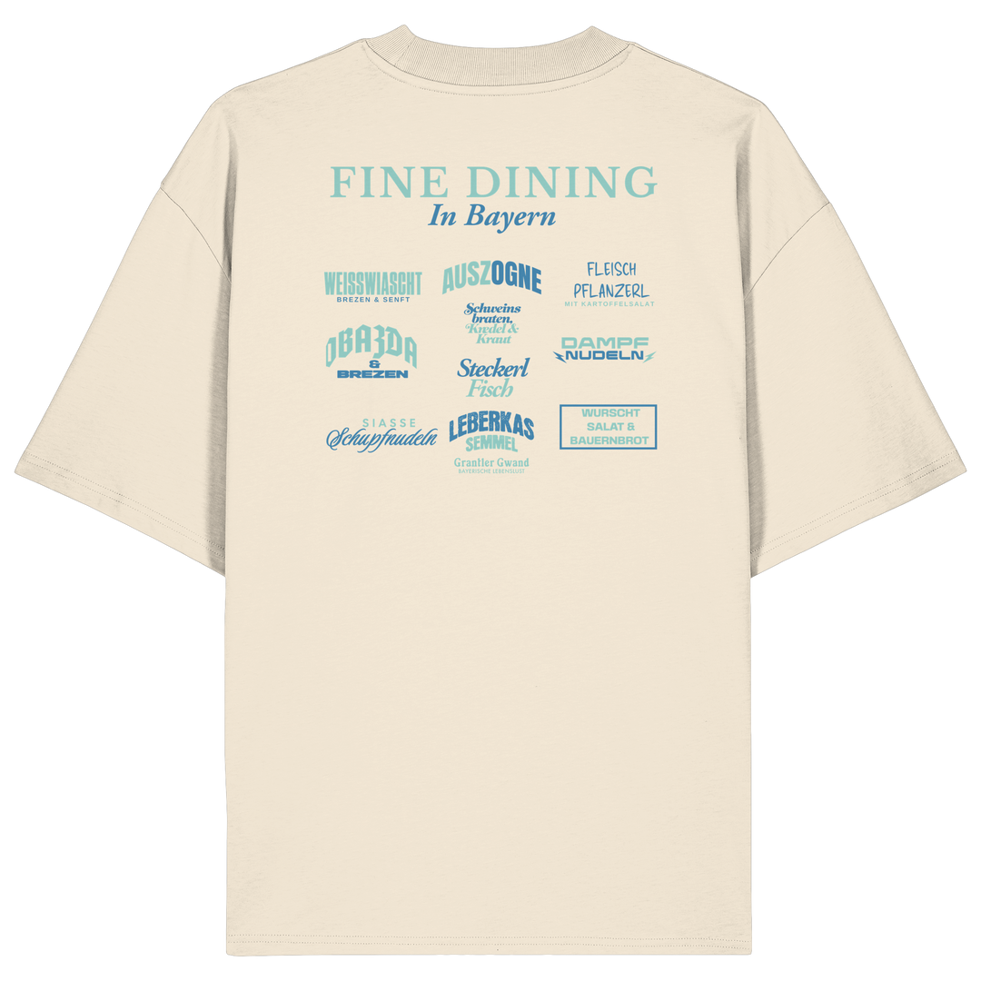 Cremefarbenes Oversize-T-Shirt in bio Qualität mit grünem „Fine Dining in Bayern“-Backprint – bayerische Streetwear mit humorvollem Motiv rund um bayerische Küche von Grantler Gwand.