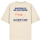 Cremefarbenes Oversize T-Shirt von Grantler Gwand mit blauem Backprint „Bayern is so vui mehr als nur a Ort“, Herzsymbol und Bayern-Silhouette – bayerisches Streetwear Shirt aus Bio-Baumwolle.