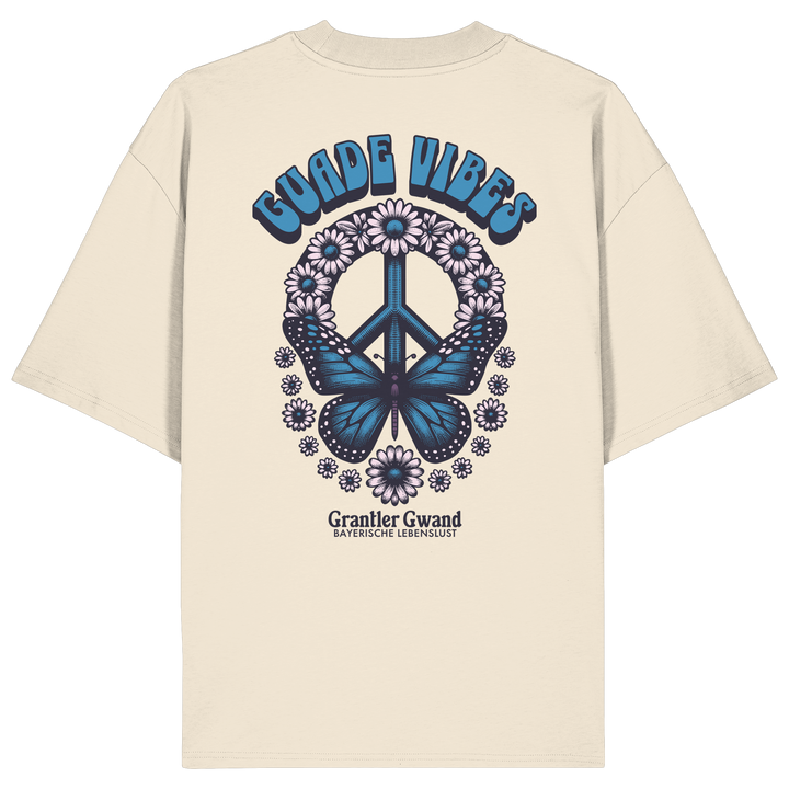 Cremefarbenes Unisex Oversize Shirt mit großem Backprint aus Peace-Zeichen, Schmetterling und Blumen sowie „Guade Vibes“ Schriftzug – hochwertiges Bio-Baumwoll Streetwear T-Shirt im bayerischen Style von Grantler Gwand.