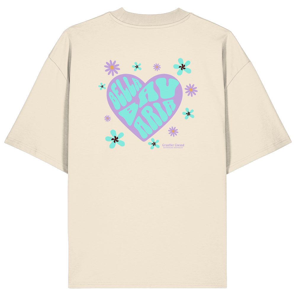 Naturfarbenes Oversize T-Shirt mit großem Herz-Backprint im Retro-Stil, floralen Elementen und dem Schriftzug „Bella Bavaria“ in Lila und Mint. Designed & bedruckt in Bayern.