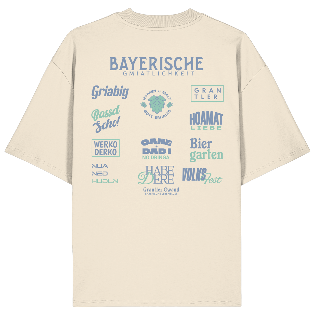 Beiges Bayerische Gmiatlichkeit Oversize Shirt mit großem grünem Backprint und bayerischen Begriffen wie Hoamatliebe, Biergarten, Volksfest, Grantler, Hopfen &amp; Malz und Griabig. Unisex Heavy Oversized T-Shirt aus Bio-Baumwolle im modernen Streetwear-Look. Designed und bedruckt in Bayern von Grantler Gwand.