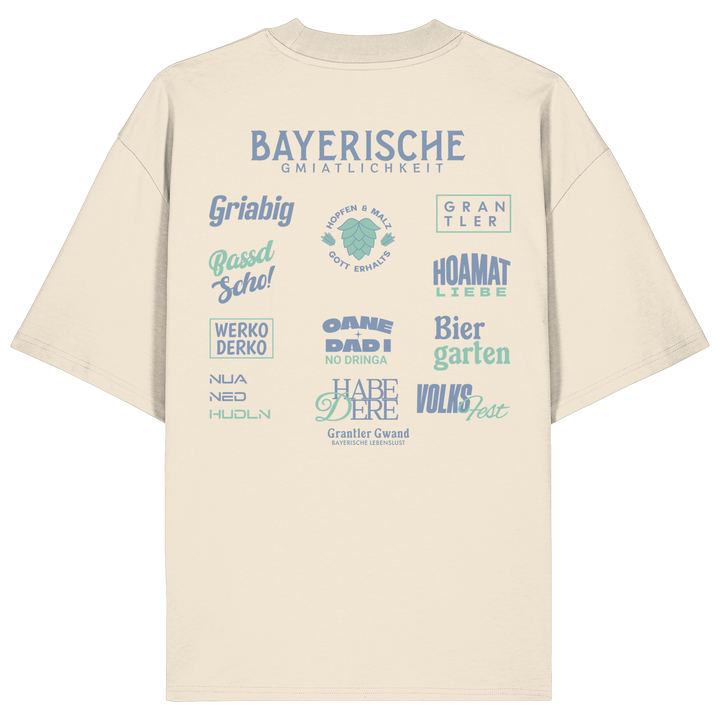 Beiges Bayerische Gmiatlichkeit Oversize Shirt mit großem grünem Backprint und bayerischen Begriffen wie Hoamatliebe, Biergarten, Volksfest, Grantler, Hopfen &amp; Malz und Griabig. Unisex Heavy Oversized T-Shirt aus Bio-Baumwolle im modernen Streetwear-Look. Designed und bedruckt in Bayern von Grantler Gwand.