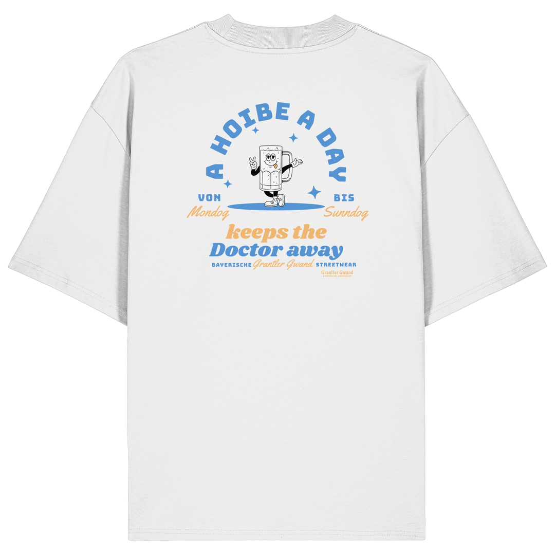 Weißes Oversize T-Shirt von Grantler Gwand mit Backprint „A Hoibe a Day keeps the Doctor away“, Bierkrug-Maskottchen im Retro-Design und hellblauen Details – bayerisches Streetwear Shirt aus Bio-Baumwolle.