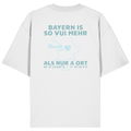 Weißes Oversize T-Shirt von Grantler Gwand mit grünem Backprint „Bayern is so vui mehr als nur a Ort“ und Bayern-Silhouette – bayerisches Streetwear Shirt aus Bio-Baumwolle.