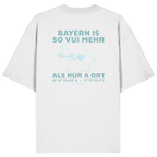 Weißes Oversize T-Shirt von Grantler Gwand mit grünem Backprint „Bayern is so vui mehr als nur a Ort“ und Bayern-Silhouette – bayerisches Streetwear Shirt aus Bio-Baumwolle.