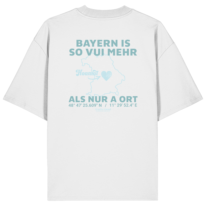 Weißes Oversize T-Shirt von Grantler Gwand mit grünem Backprint „Bayern is so vui mehr als nur a Ort“ und Bayern-Silhouette – bayerisches Streetwear Shirt aus Bio-Baumwolle.