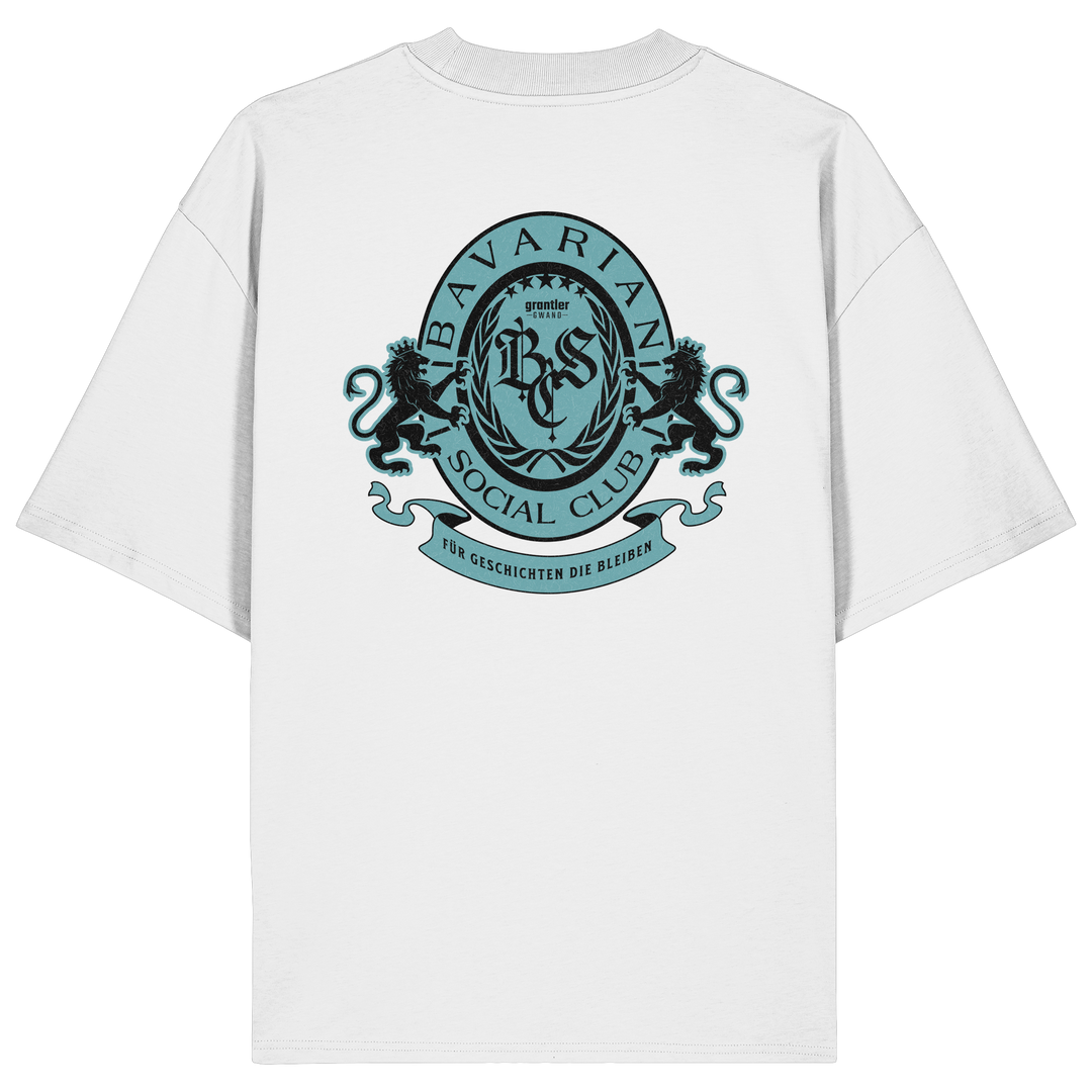 Weißes Oversize T-Shirt mit großem mintfarben-schwarzem Bavarian Social Club Wappen auf dem Rücken, verziert mit zwei Löwen, Lorbeerkranz und dem Schriftzug „Für Geschichten die bleiben“.
