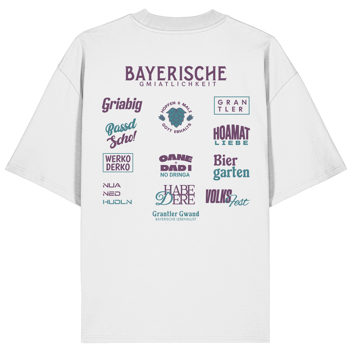 Weißes Oversize-Shirt mit großem lila Backprint „Bayerische Gmiatlichkeit“ und typischen bayerischen Begriffen wie Hoamatliebe, Biergarten, Volksfest, Grantler, Hopfen &amp; Malz und Griabig. Unisex Premium-Shirt aus Bio-Baumwolle im modernen Streetwear-Style. Designed und bedruckt in Bayern von Grantler Gwand.