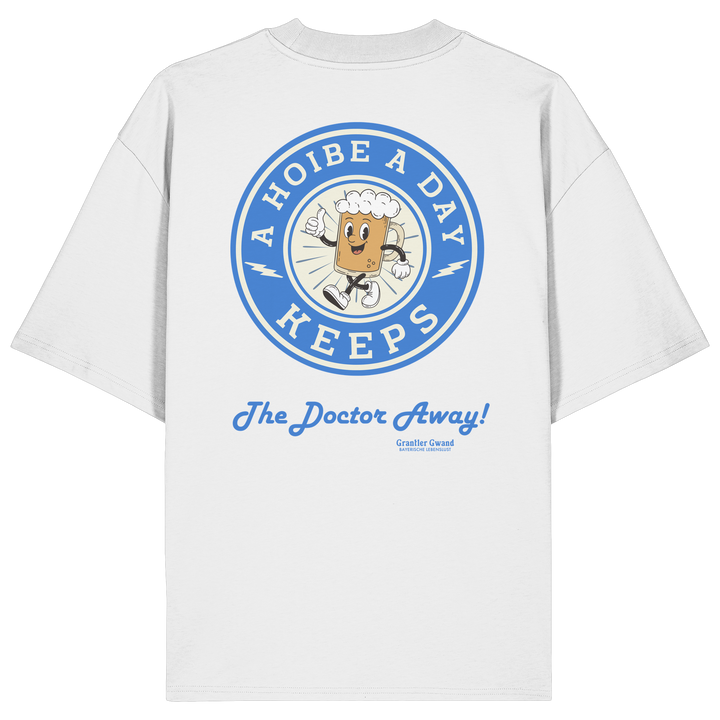 Oversize Unisex-Shirt in Weiß mit großem Backprint „A Hoibe A Day – Keeps the Doctor Away“ im Retro-Bierdeckel-Design mit blauen Akzenten. Modernes bayerisches Streetwear-Shirt für Biergarten, Volksfest und gesellige Momente. Designed und bedruckt in Bayern von Grantler Gwand.