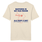 Cremefarbenes Unisex T-Shirt von Grantler Gwand mit blauem Backprint „Bayern is so vui mehr als nur a Ort“, Herzsymbol und Bayern-Silhouette – bayerisches Streetwear T-Shirt aus 100 % Baumwolle.
