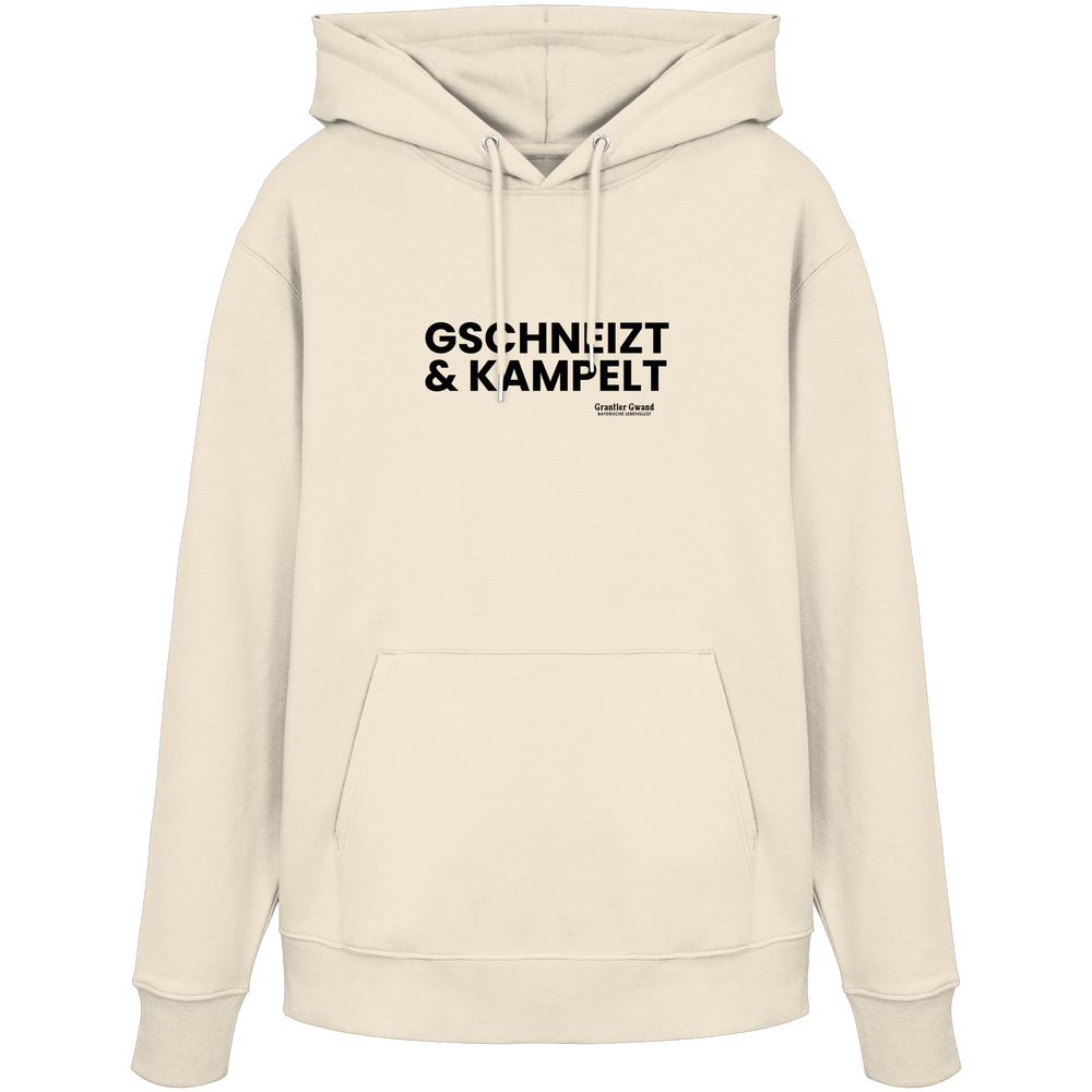 Beiger Hoodie mit schwarzem Frontprint „Gschneizt & Kampelt“. Moderner Unisex-Hoodie mit bayerischem Dialekt im minimalistischen Streetwear-Design für Volksfest, Biergarten und Alltag. Hochwertige Qualität, designed und bedruckt in Bayern von Grantler Gwand.