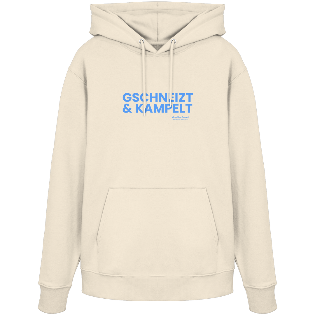 Beiger Unisex-Hoodie mit blauem Frontprint „Gschneizt & Kampelt“. Moderner bayerischer Hoodie mit Dialekt-Motiv für Volksfest, Biergarten und Alltag. Hochwertig verarbeitet, designed und bedruckt in Bayern von Grantler Gwand.
