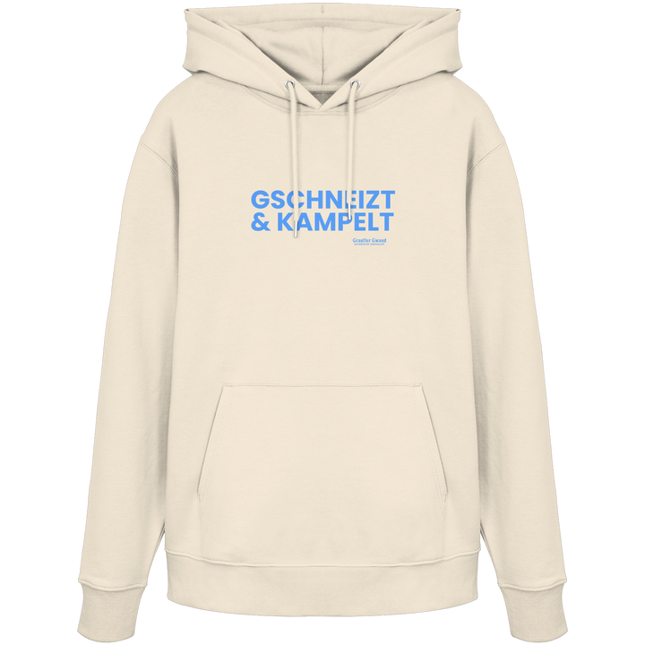 Beiger Unisex-Hoodie mit blauem Frontprint „Gschneizt &amp; Kampelt“. Moderner bayerischer Hoodie mit Dialekt-Motiv für Volksfest, Biergarten und Alltag. Hochwertig verarbeitet, designed und bedruckt in Bayern von Grantler Gwand.