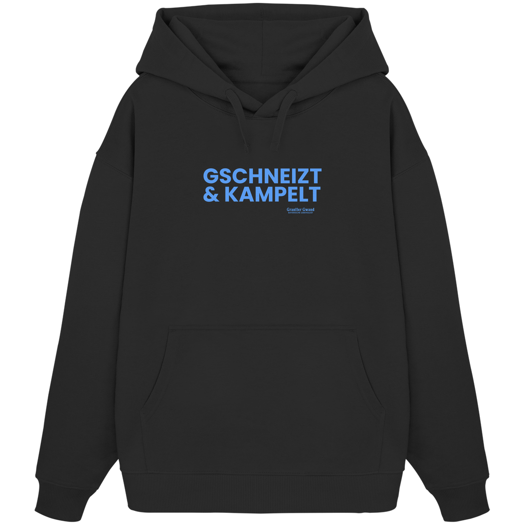 Schwarzer Oversize-Hoodie mit blauem Frontprint „Gschneizt &amp; Kampelt“. Moderner bayerischer Streetwear-Hoodie mit Dialekt-Motiv für Volksfest, Biergarten und Alltag. Extra schwerer Premium-Hoodie, designed und bedruckt in Bayern von Grantler Gwand.