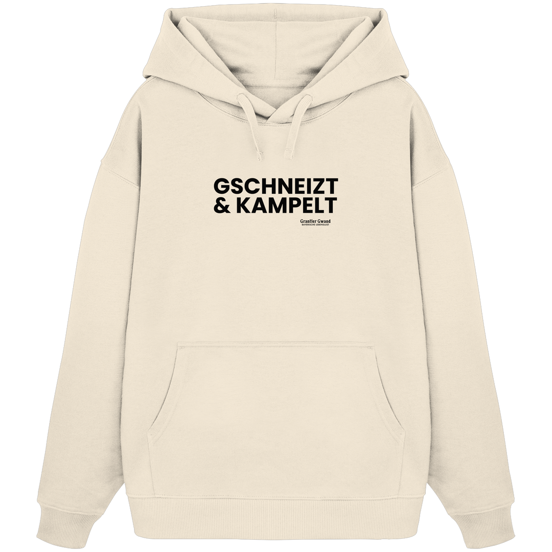 Beiger Oversize-Hoodie mit schwarzem Frontprint „Gschneizt &amp; Kampelt“. Moderner Hoodie mit bayerischem Dialekt im minimalistischen Streetwear-Design für Volksfest, Biergarten und Alltag. Hochwertige Qualität, designed und bedruckt in Bayern von Grantler Gwand.