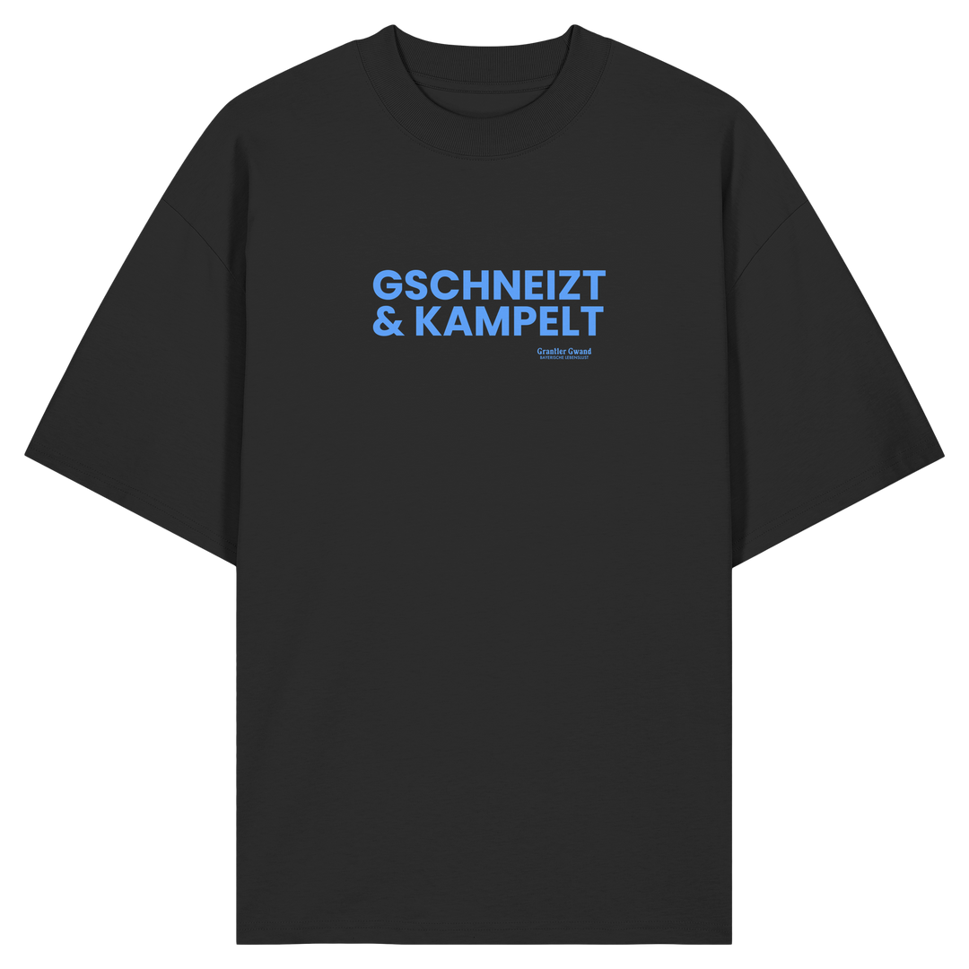 Schwarzes Oversize-T-Shirt mit blauem Frontprint „Gschneizt &amp; Kampelt“. Modernes bayerisches Streetwear-Shirt mit Dialekt-Motiv für Volksfest, Biergarten und Alltag. Hochwertige Bio-Baumwolle, designed und bedruckt in Bayern von Grantler Gwand.