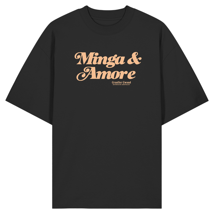 Schwarzes Oversize T-Shirt von Grantler Gwand mit apricotfarbenem Frontprint „Minga &amp; Amore“ im Retro-Schriftzug – bayerisches Streetwear Shirt aus Bio-Baumwolle.
